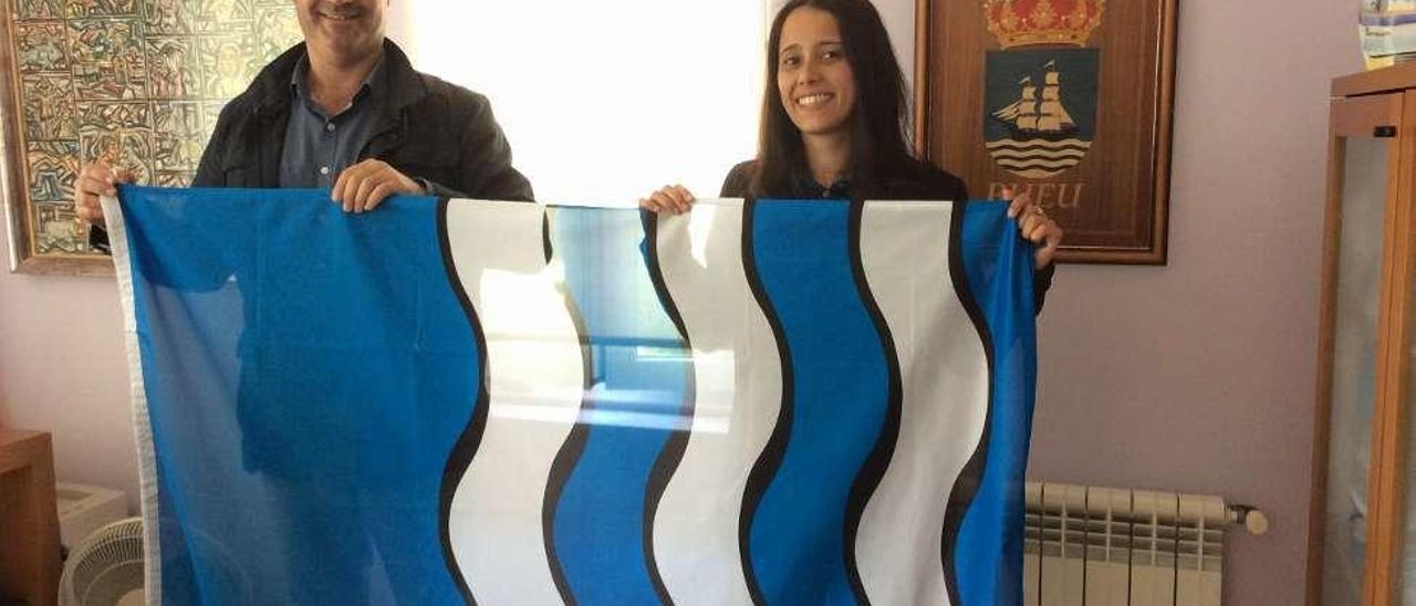 Félix Juncal y Silvia Carballo muestran la bandera oficial del Concello de Bueu. // S.Á.