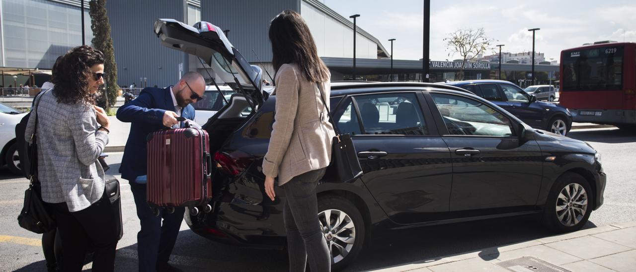 Un conductor de VTC recoge las maletas de varias clientes, en València, en marzo de 2019.