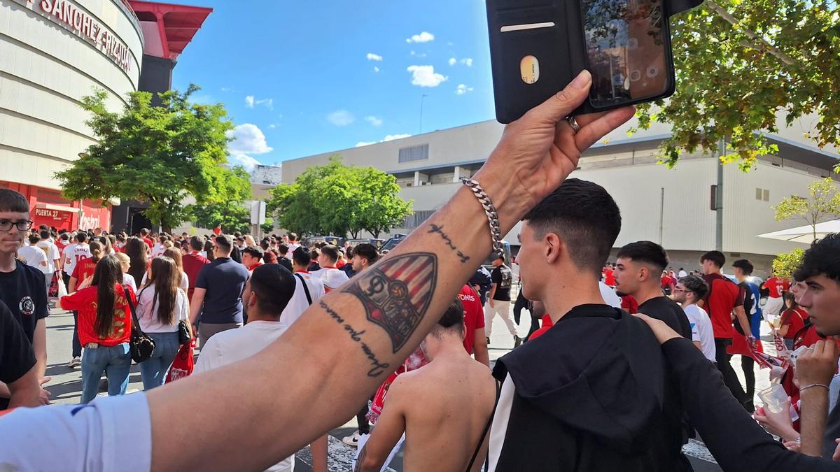 Un aficionado muestra el tatuaje con el escudo del Sevilla FC a las afueras del Sánchez Pizjuán