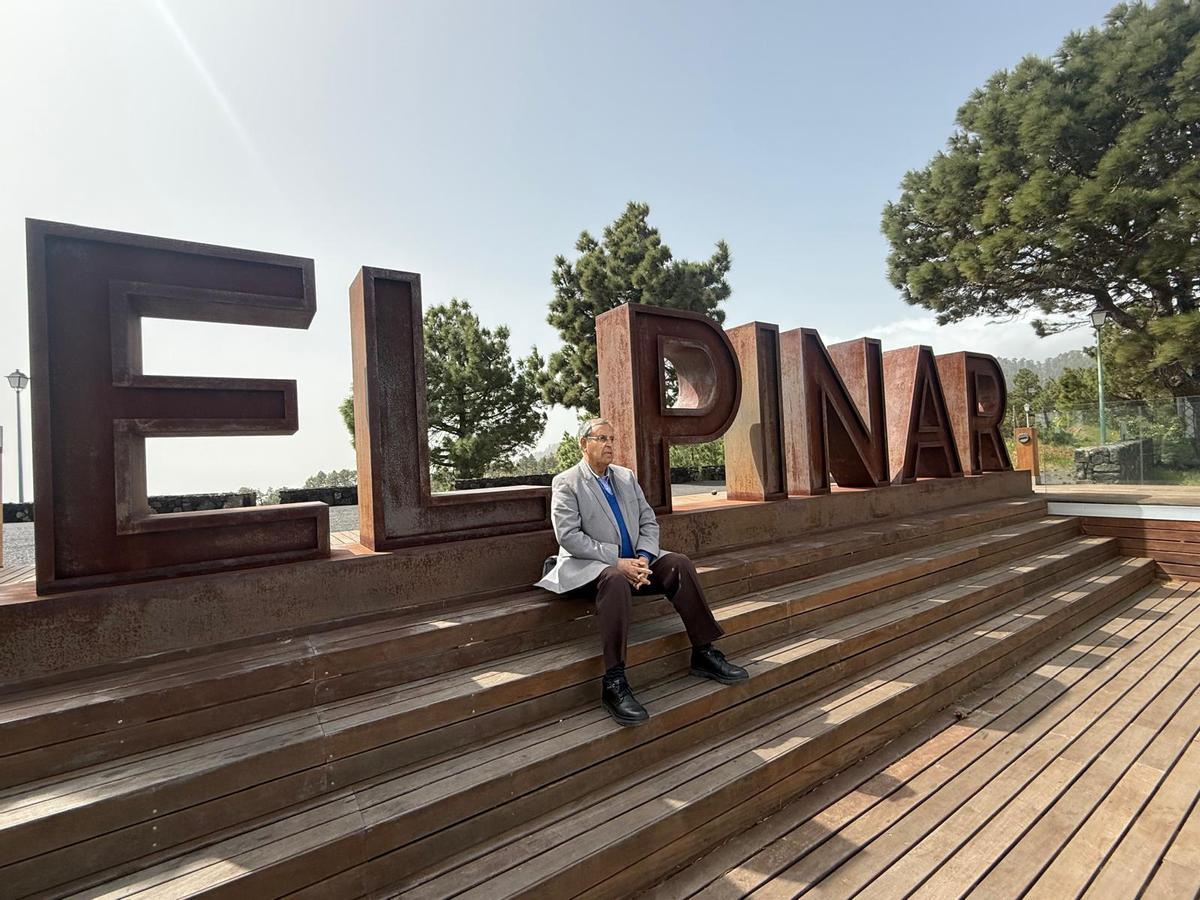 Juan Miguel Padrón, sentado junto a una leyenda metálica de El Pinar en la zona del mirador de Tajanada.