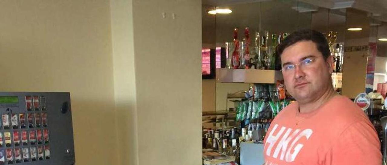 El dueño del bar muestra el lugar donde estaba la máquina. / Muñiz