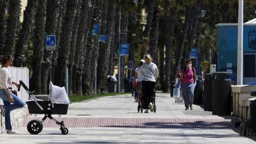 Varias madres con sus hijos pasean por la playa de la Malagueta, este miércoles.