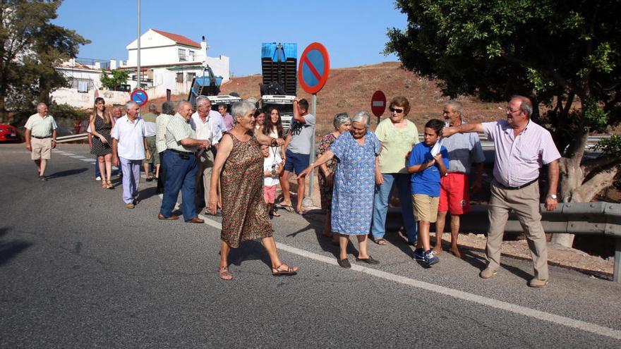 Un grupo de vecinos de la parte alta de la Mosca, en julio de 2016, se dirige a la parada de la línea 29 de la EMT por los carriles de acceso a la autovía.