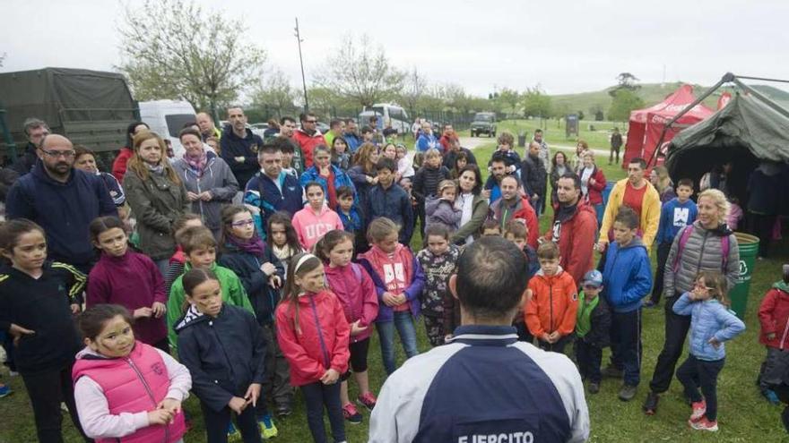 Un militar explica a los niños la forma en la que se desarrollaría la carrera de orientación en Bens.