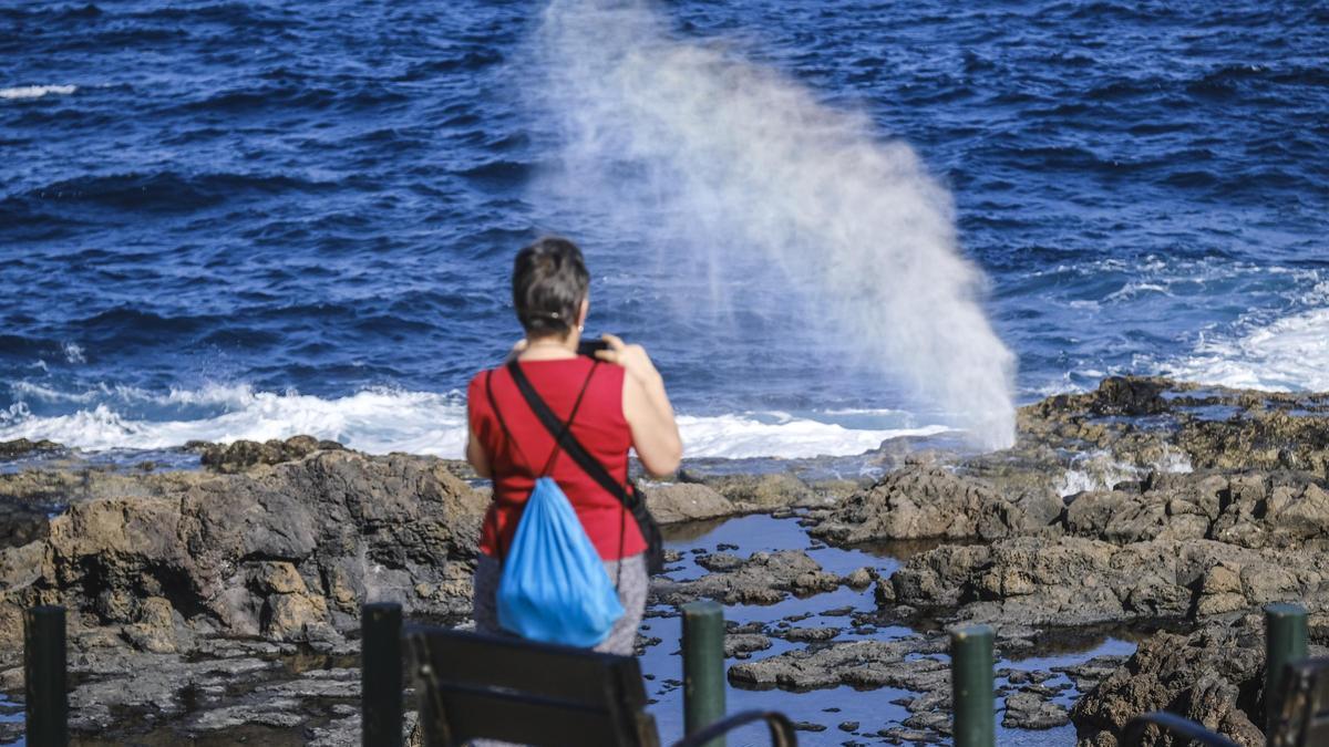 UNA TURISTA FOTOGRAFÍA EL BUFADERO DE LA GARITA DESDE EL MIRADOR HABILITADO JUNTO AL PASEO MARÍTIMO