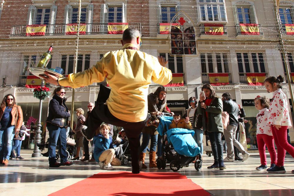 Muchos malagueños y turistas aprovechan el buen tiempo y el día festivo por la Inmaculada Concepción para pasear y realizar las compras navideñas en el Centro de Málaga.