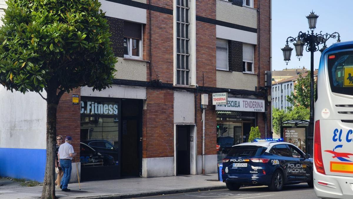 Un vehículo de la Policía Nacional delante del portal de la vivienda en la que fue hallado el hombre.