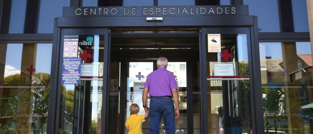 Un hombre y un niño pequeño acceden al centro de especialidades de O Ventorrillo.  | // CARLOS PARDELLAS