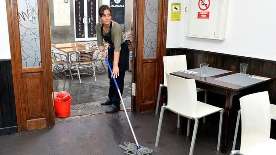 Esther Santana limpia la entrada del restaurante tras las lluvias del pasado martes.