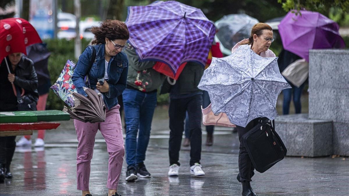 Varias personas se protegen de la lluvia en Valencia,  donde se ha decretado alerta por lluvias torrenciales