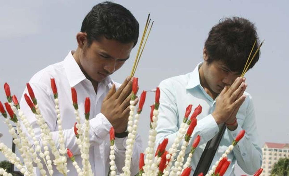 Dos joves resen per la seva amiga Srey Mom, de 21 anys, que va morir dilluns al quedar atrapada al pont de vianants que connecta la capital cambodjana amb l’illa de Koh Pich (Cambodja).