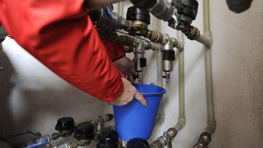 Un vecino vacía los filtros instalados en las tomas de agua de un edificio.