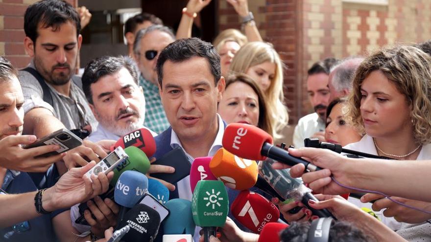 Juanma Moreno, Regionalpräsident von Andalusien, spricht vor einem Wahllokal mit Journalisten.