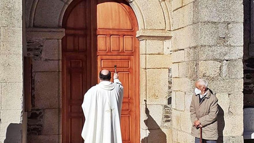 El párroco y arcipreste Fernando Lorenzo bendice las nuevas puertas. |Ch.S.