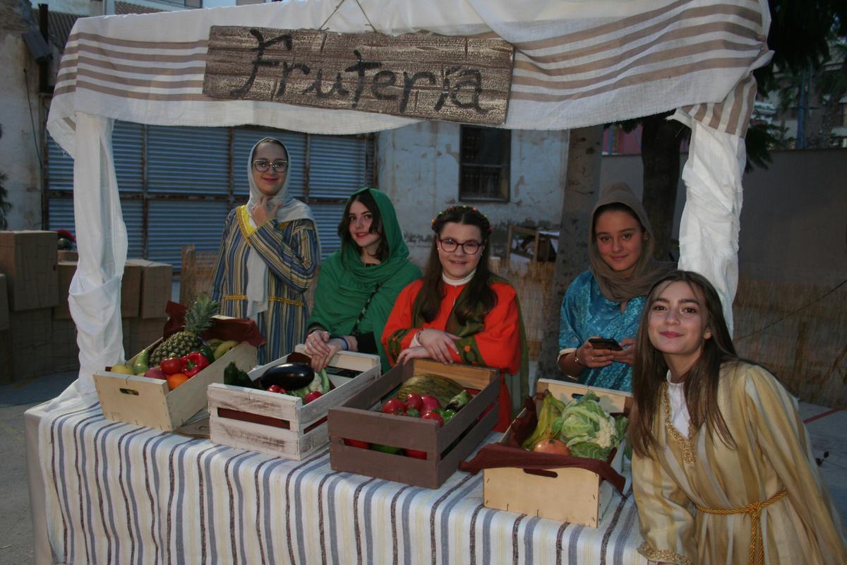 Un grupo de alumnas en un puesto de fruta del mercado del belén.