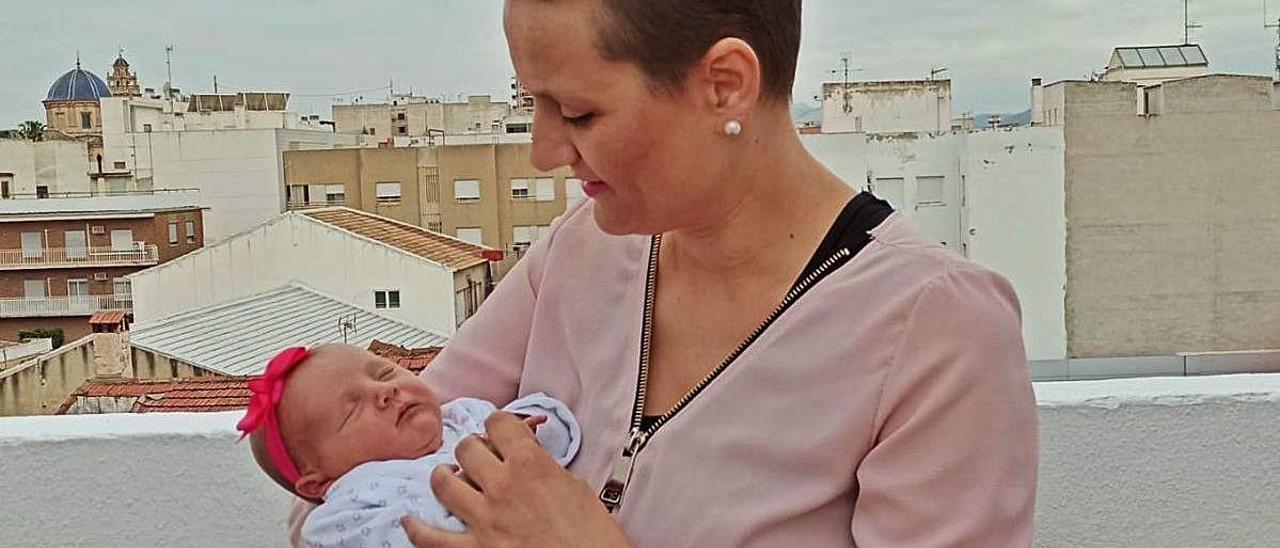 Olga María Abellán, con la pequeña Andrea, en la terraza de su domicilio.