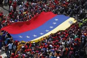 Seguidors del president Hugo Chávez estenen una bandera nacional gegant mentre esperen el pas del cotxe fúnebre.