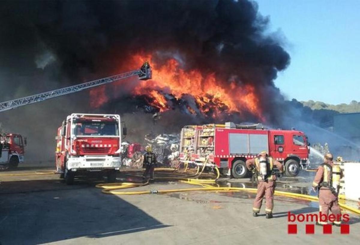 Vint dotacions de bombers treballen per controlar l’incendi en l’empresa de desballestament de vehicles.