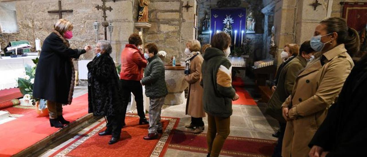 La concejala del PSOE María Canosa Otero repartiendo la comunión en la iglesia de Santa Cristina de Cobres. | // GUSTAVO SANTOS