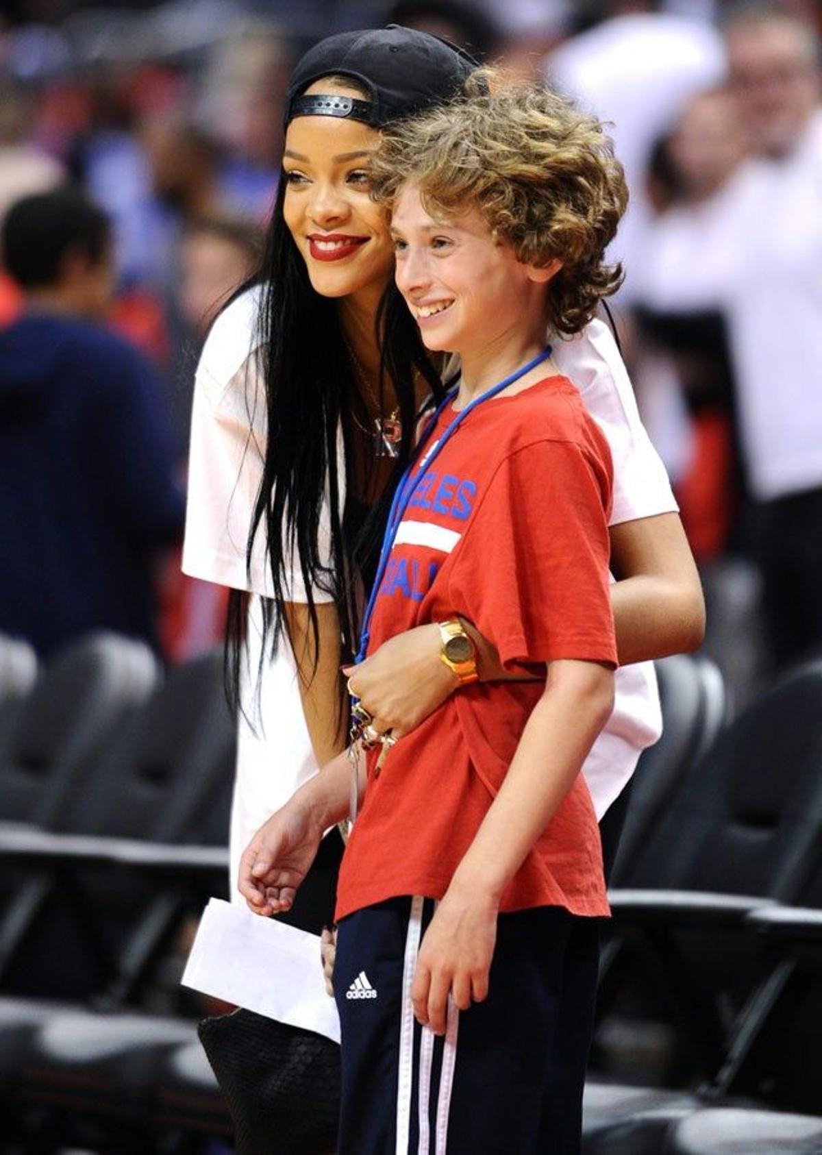 Rihanna posa con un joven fan en el descanso del partido