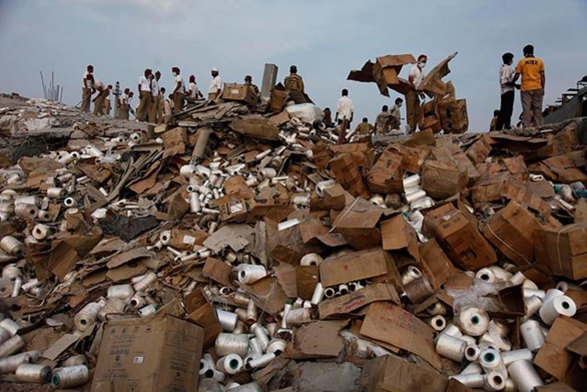 Un grup de treballadors miren de trobar els seus companys enterrats entre la runa d’una fàbrica que s’ha ensorrat a Jalandhar (Índia).