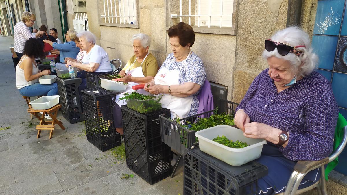 Un grupo de personas elabora la materia vegetal para las alfombras. / A.P.