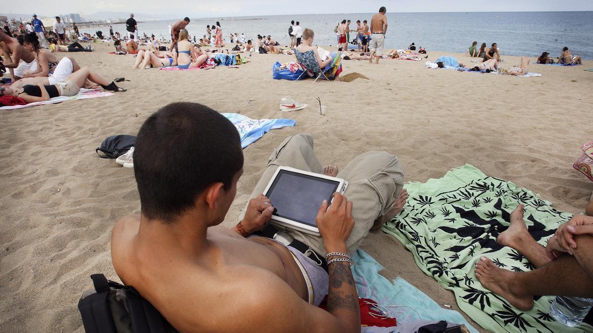 Un hombre trabaja desde la playa durante sus vacaciones.