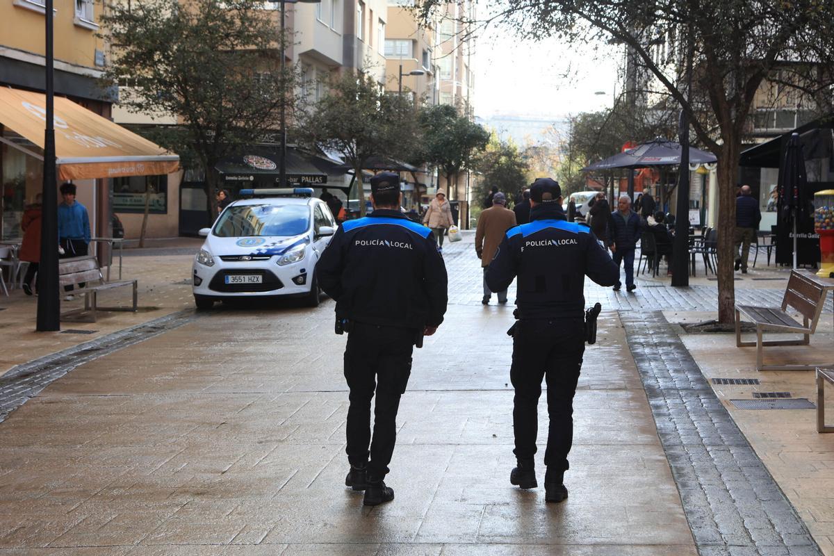 Dos policías locales patrullan la calle Ángel Senra