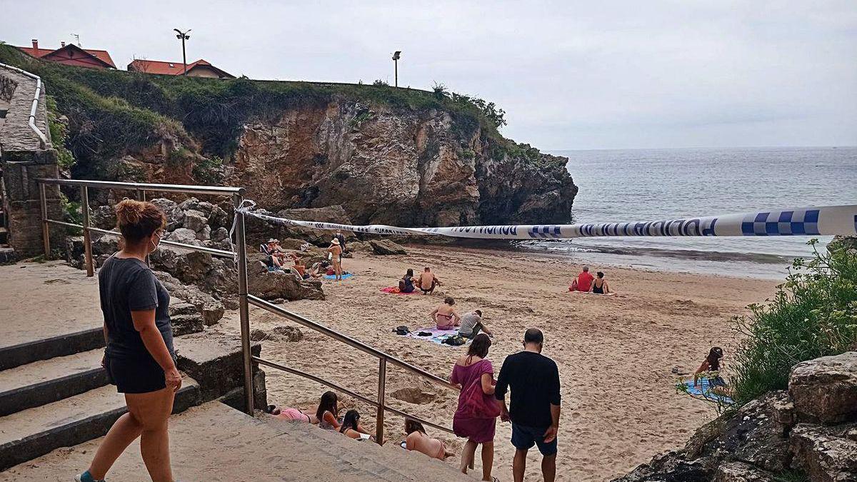 Varios usuarios, en la playa de Puertu Chicu de Llanes, cerrada por la Policía Local.