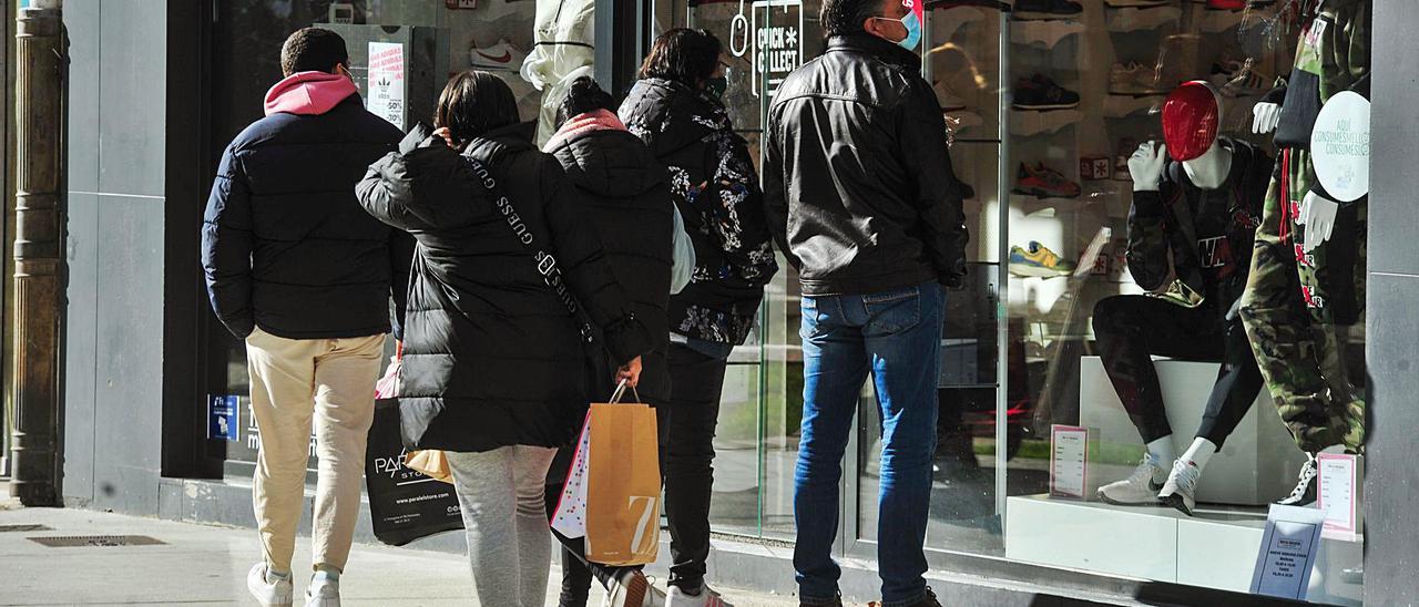 Gente caminando y mirando un escaparate en el centro de Vilagarcía, ayer. |   // IÑAKI ABELLA