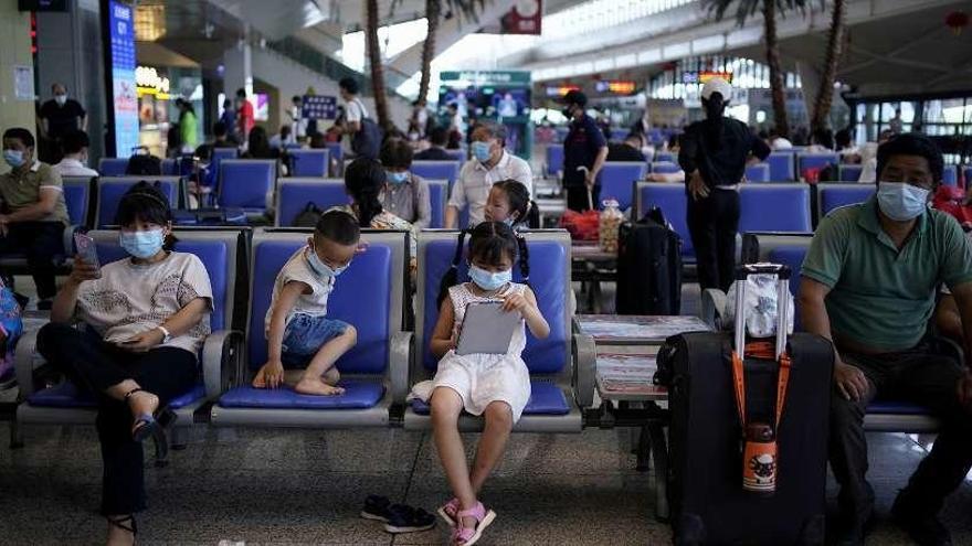Una familia con mascarillas, en una estación de autobuses de la ciudad china de Wuhan. Reuters