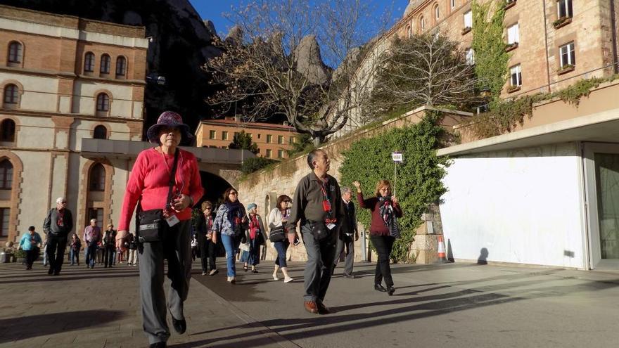 Grup de turistes passant per davant del museu de Montserrat seguint un guia