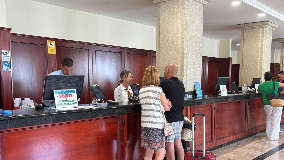 Dos personas realizan el ‘check-in’ en la recepción de un alojamiento ubicado en Peñíscola, en una imagen de archivo.