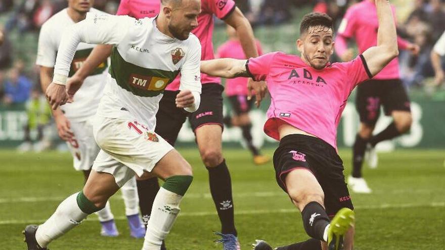 Felipe Alfonso disputa un balón con la camiseta rosa del Alcorcón al delantero del Elche Iván Sánchez la pasada temporada