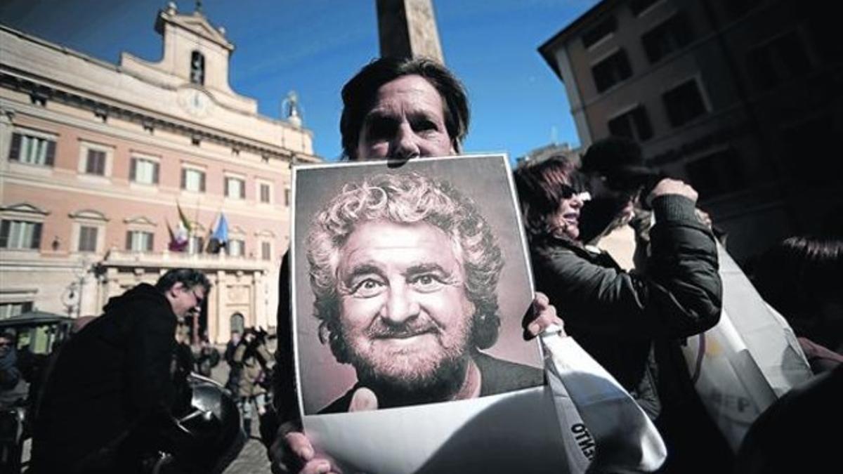 Un simpatizante del M5S lleva un póster con la imagen de Beppe Grillo en una concentración ante el Parlamento, el pasado 15 de febrero, cuando Matteo Renzi buscaba formar Gobierno.