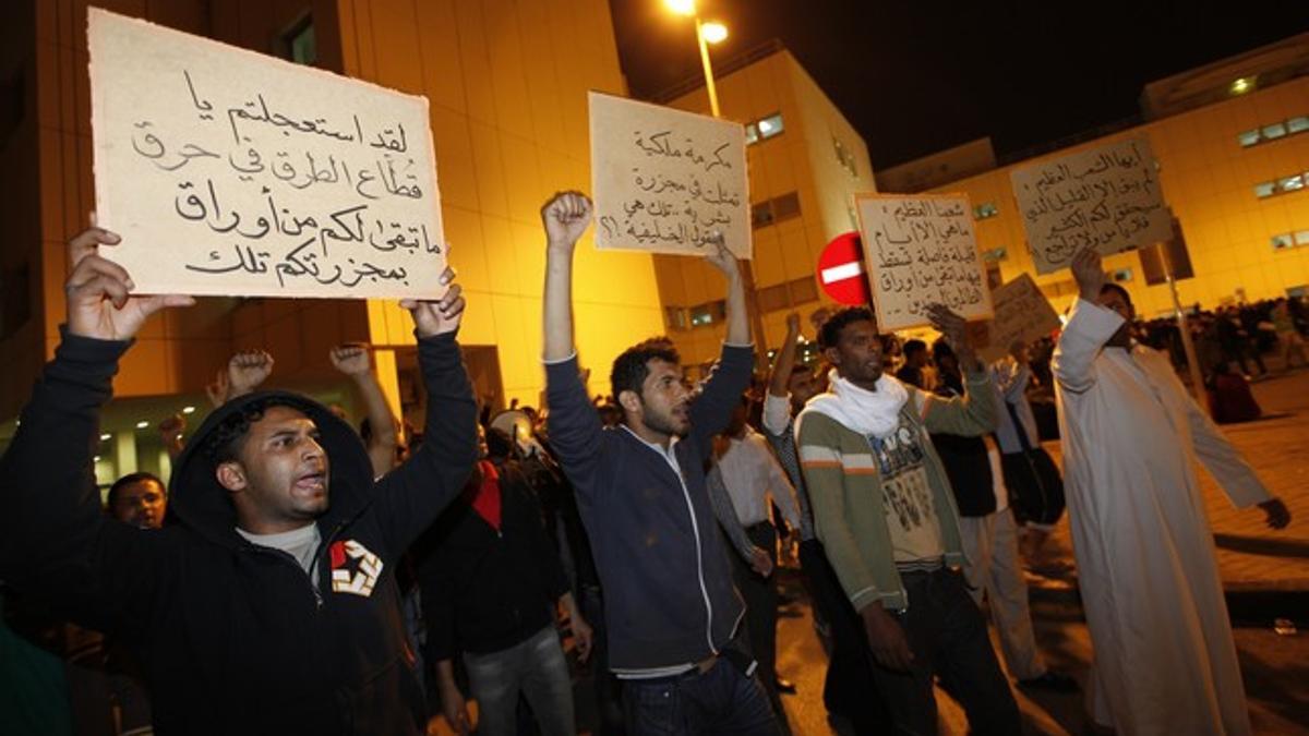 Ciudadanos de Bahréin protestan contra el régimen después de la carga policial de la plaza de la Perla, la noche del jueves en Manama.