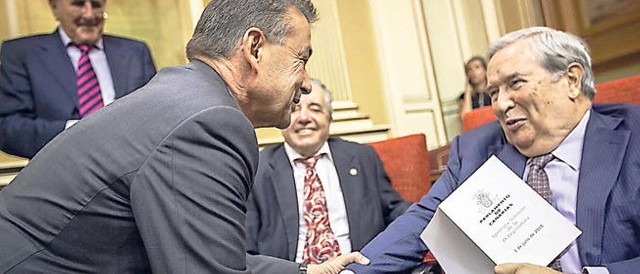 Jerónimo Saavedra saluda al expresidente del Gobierno Paulino Rivero en un acto en el Parlamento de Canarias.
