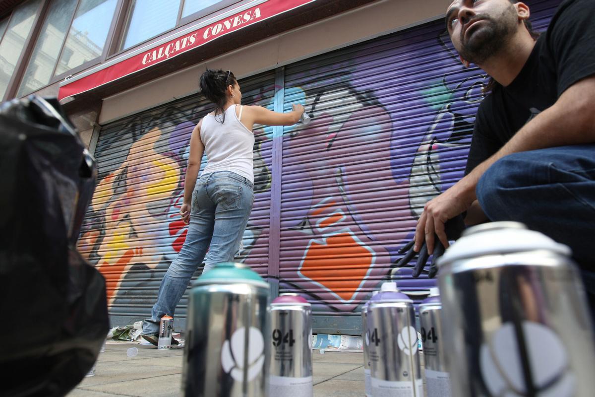 BARCELONA 26/09/2010 BARCELONA ARTISTAS URBANOS PINTAN PERSIANAS DE COMERCIOS EN LA PLA?A DE LA LLIBERTAT DE GRACIA FOTO ELISENDA PONS. GRAFFITI , GRAFITIS , GRAFITI , GRAFITOS , PINTURA EN LA CALLE , AUTORIZACION MUNICIPAL A GRAFITEROS , PERMISO AYUNTAMIENTO BCN , DECORACION PERSIANAS TIENDAS COMERCIO MERCADO MERCAT DE LA LLIBERTAT , BARRIO DE GRACIA , _ PUBLICADA EPC 27/09/2010 P 29 _ MEDIO , PLANO