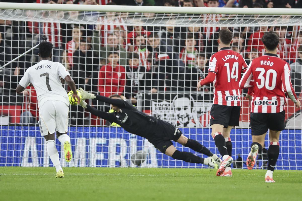 BILBAO, 03/12/2025.-El portero del Athletic Club de Bilbao Unai Simón y el delantero del Real Madrid Vinicius JR, durante el partido de la jornada 19 de LaLiga EA Sports entre el Athletic Club y el Real Madrid, este miércoles en el estadio de San Mamés en Bilbao.- EFE/ Luis Tejido