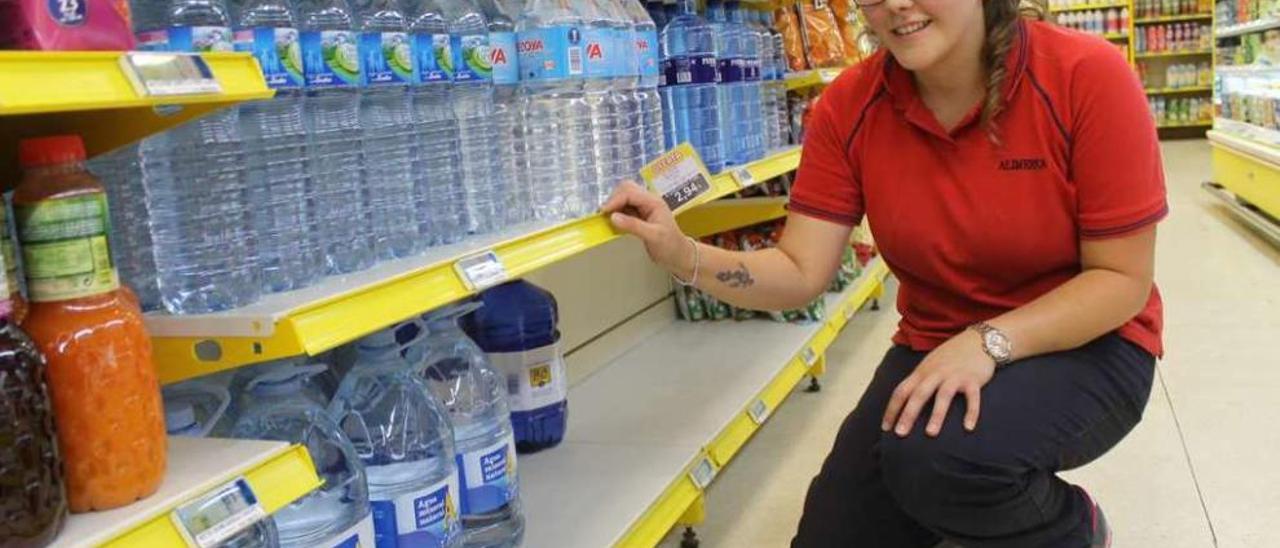 Isabel García, encargada de un céntrico supermercado de Luarca, junto a la estantería del agua, ayer, sin apenas ya garrafas a la vista.