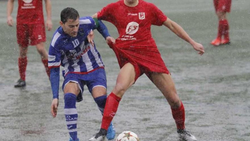 Dos jugadores pugnan por el balón en el encharcado campo de A Gándara, en el partido de ayer. // A. Irago