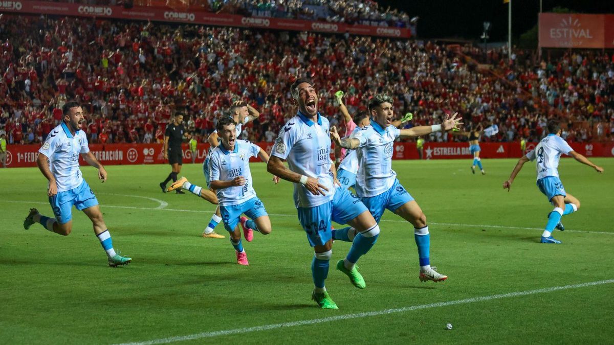 Los jugadores del Málaga CF celebran el gol de Antoñito Cordero que dio el ascenso al equipo blanquiazul en el Nou Estadi de Tarragona. | AGENCIA LOF
