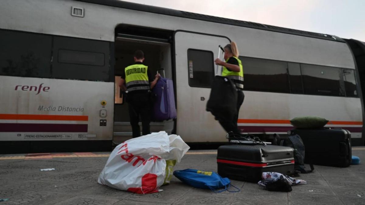 El personal de seguridad, junto a las maletas y efectos personales de los pasajeros que viajan en el tren de media distancia que sufrió el siniestro alrededor de las 18.00 horas de ayer. | GERMÁN CABALLERO