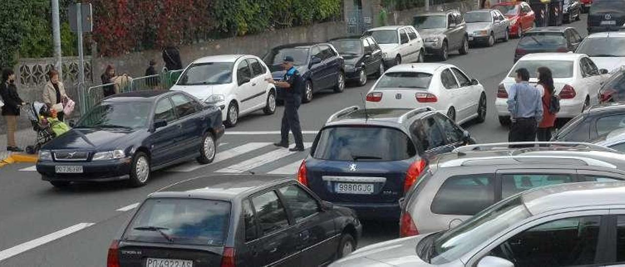 Tráfico en una calle del casco urbano de Lalín, con agentes de policía regulando el tráfico. // Bernabé