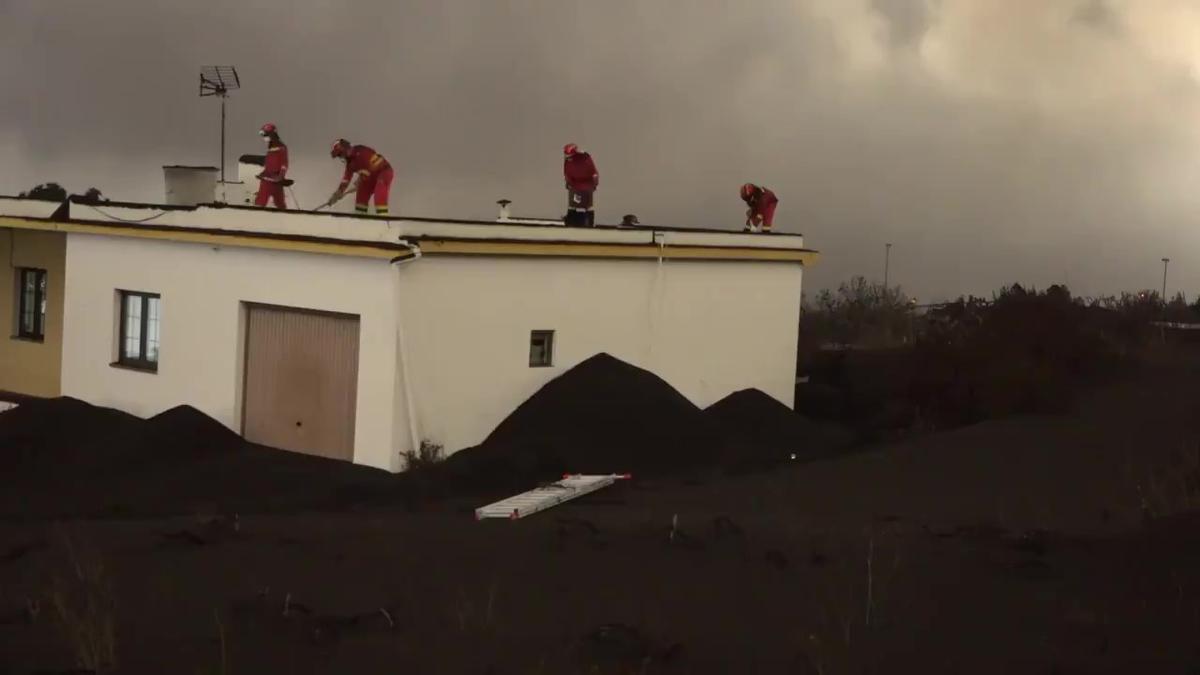 Efectivos de la UME y del Ejército de Tierra retiran cenizas del volcán en azoteas de La Palma.