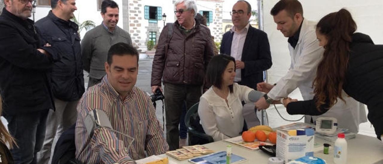 Diego Ojeda y Saraiba Leal, ayer, durante la toma de la tensión arterial en un puesto de la plaza de San Juan.