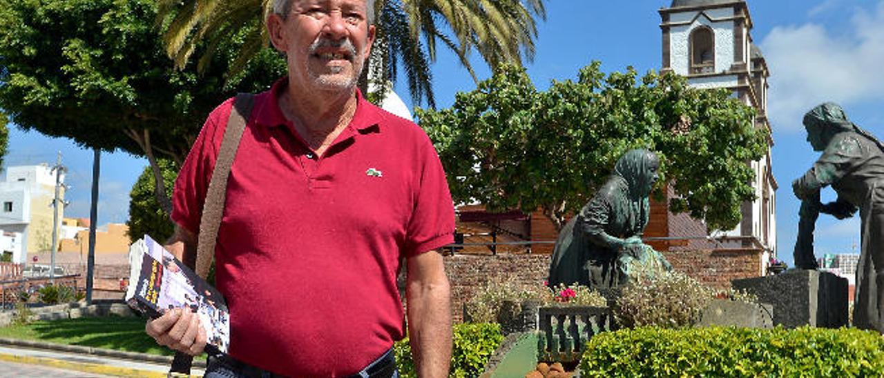 Juan José Espino del Toro con su libro ante las lavanderas y la iglesia de la Candelaria de Ingenio.