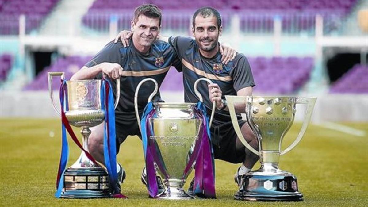 Tito y Pep posan con sus tres primeros títulos, de la campaña 2008-09: La Copa del Rey, la Liga de Campeones y la Liga española.