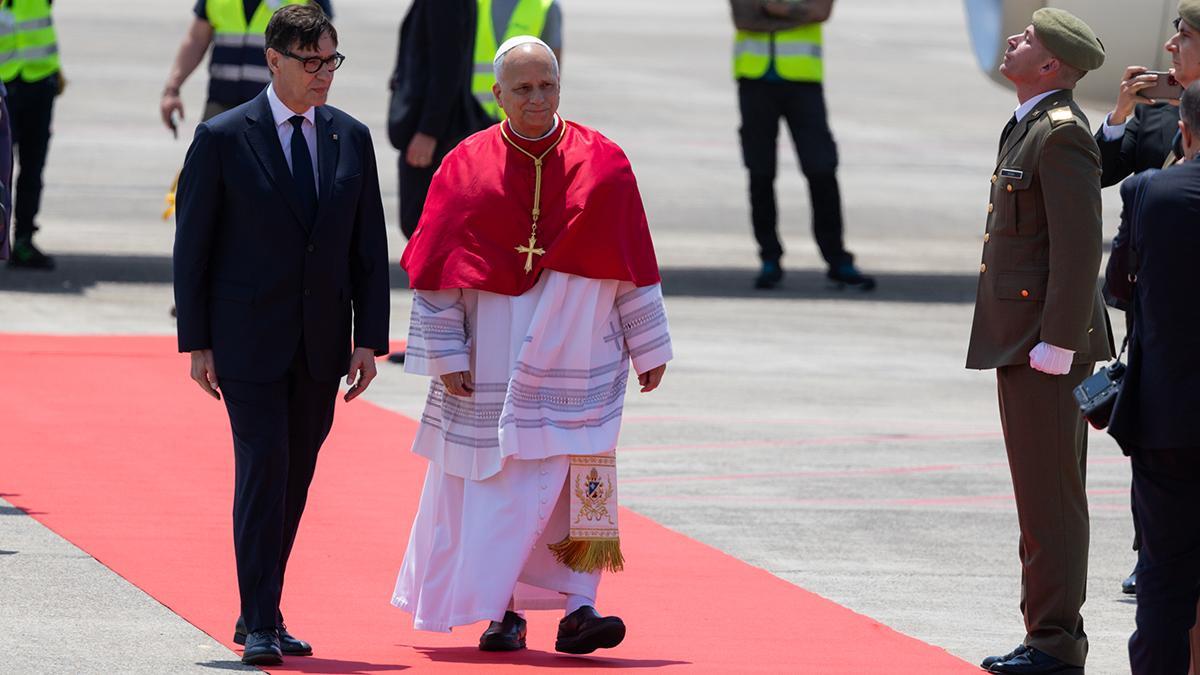 El papa León XIV, a su llegada al aeropuerto de Barcelona. A su lado, el presidente de la Generalitat, Salvador Illa.