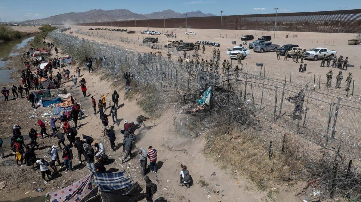 Migrantes acampan a lo largo de la orilla del río Grande mientras esperan entregarse a las autoridades de inmigración en El Paso, Texas, EE.UU